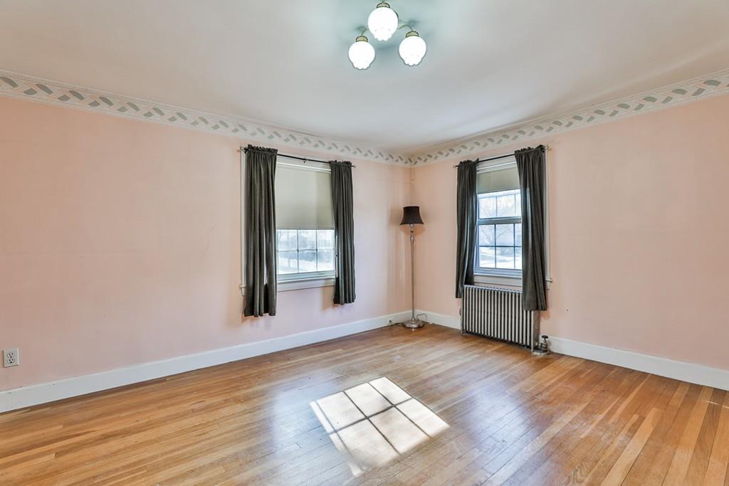 554 Brook Road Milton, MA 02186 - Photo 15 of 22 an empty room with wooden floor and windows
