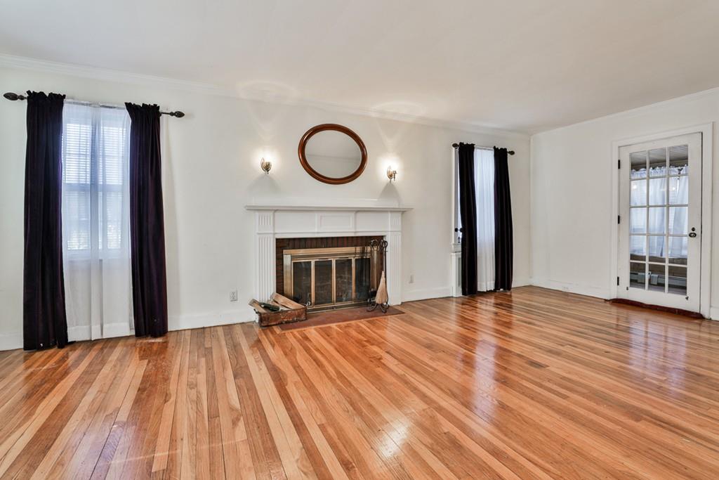 554 Brook Road Milton, MA 02186 - Photo 3 of 22 a view of empty room with wooden floor and fireplace