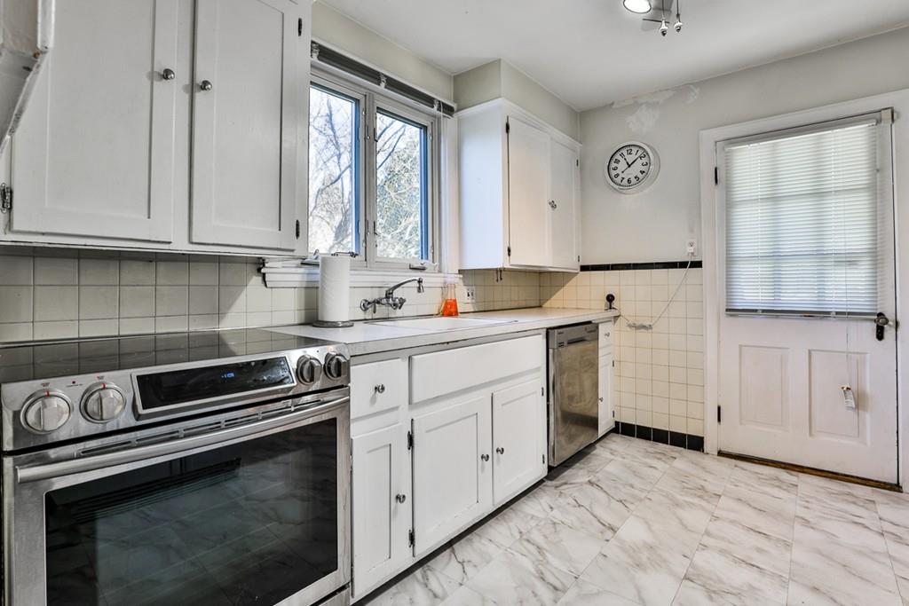 554 Brook Road Milton, MA 02186 - Photo 9 of 22 a kitchen with granite countertop white cabinets and white appliances