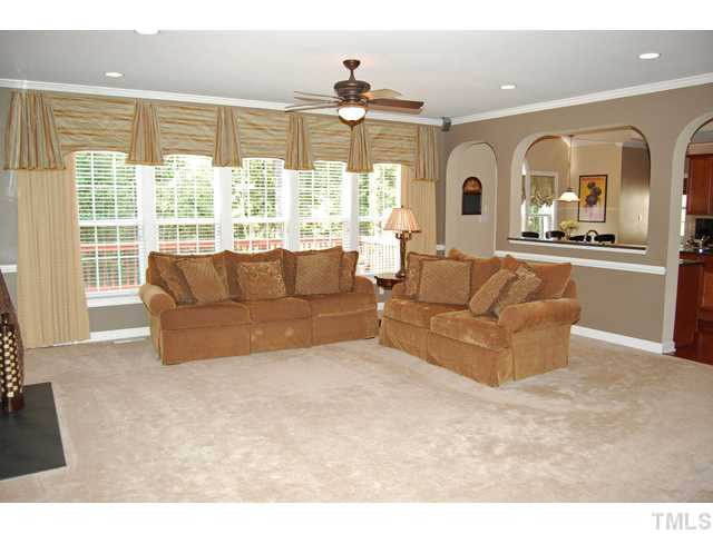 9219 Stone Mountain Road Raleigh, NC 27613 - Photo 11 of 25 The inviting family room has a gas fireplace flanked with built-in bookshelves, carpet, and a wall of windows. Den/Family/Great Room