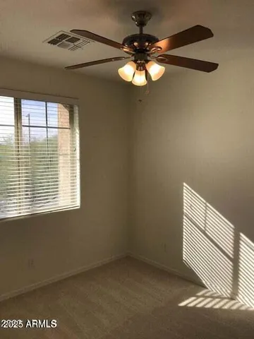 a view of room with a ceiling fan and window