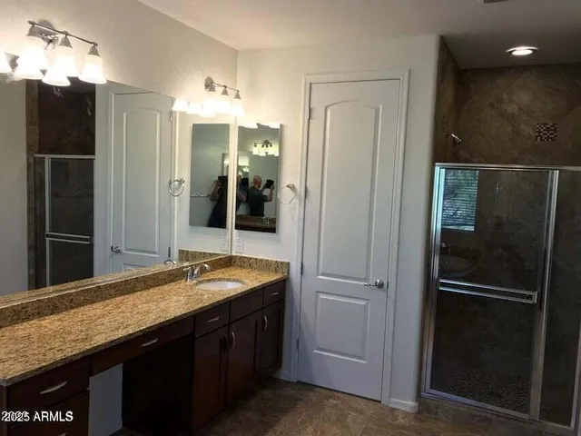 a bathroom with a granite countertop sink shower and a mirror