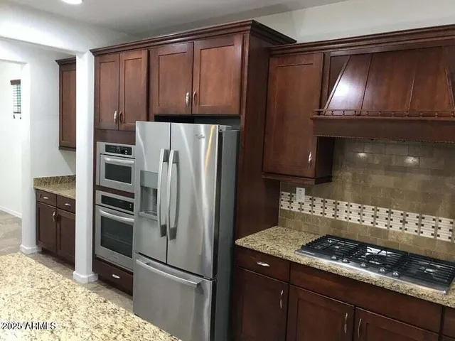 a kitchen with granite countertop stainless steel appliances and wooden cabinets
