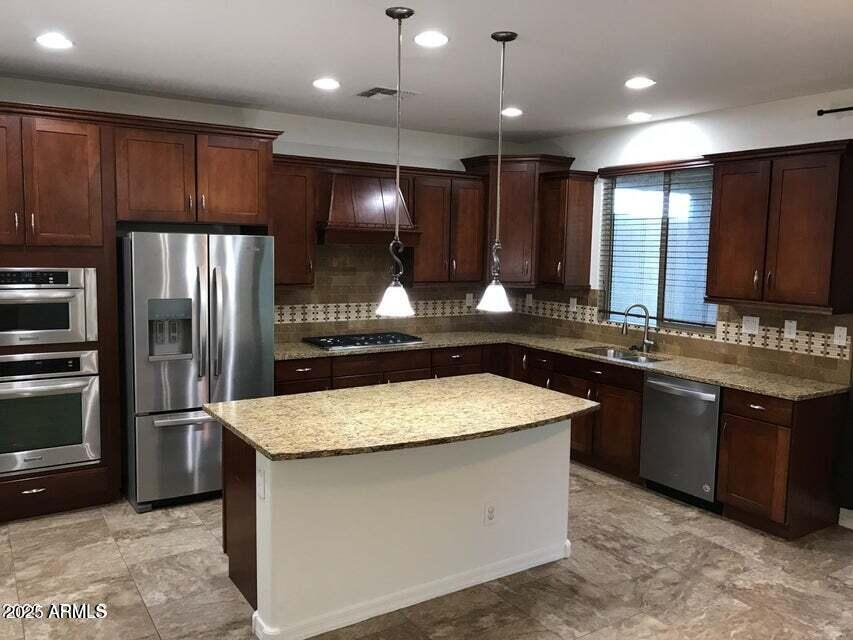 3838 East Cat Balue Drive Phoenix, AZ 85050 - Photo 5 of 22 a kitchen with kitchen island granite countertop wooden cabinets a refrigerator and a sink