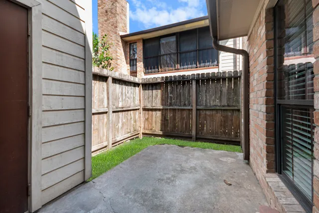 a view of a house with a yard and wooden fence