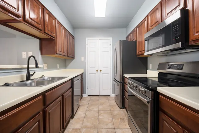 a kitchen with stainless steel appliances granite countertop a sink stove and cabinets