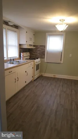 a kitchen with granite countertop white cabinets and window