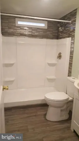 a bathroom with a toilet and a shower