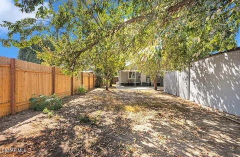 a view of a yard with wooden fence