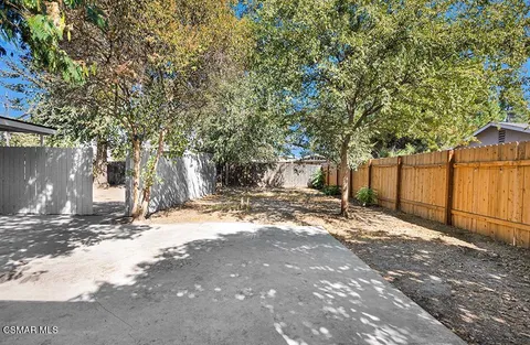 a view of a house with a yard and large tree