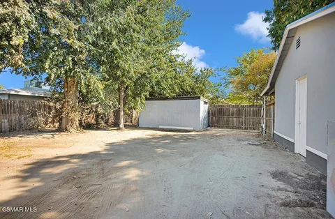 a view of an house with backyard and trees