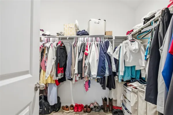 a view of walk in closet with clothes