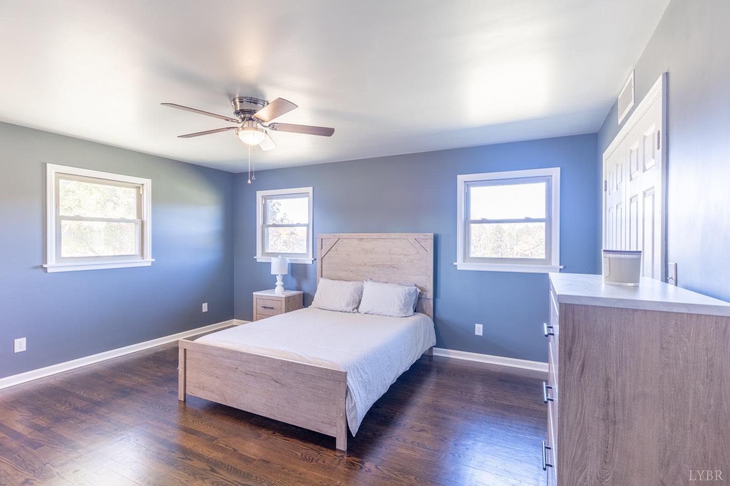 5461 Red House Road Rustburg, VA 24588 - Photo 13 of 47 a bedroom with a large bed chandelier and a window