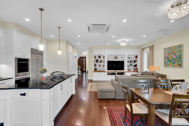 a large kitchen with kitchen island a flat screen tv and living room