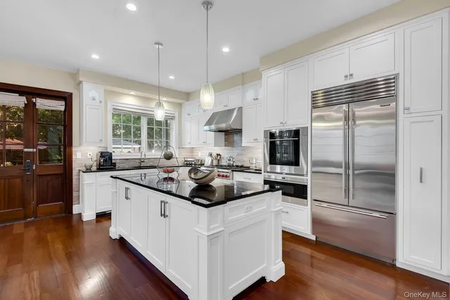 a kitchen with kitchen island a stove a sink and a refrigerator