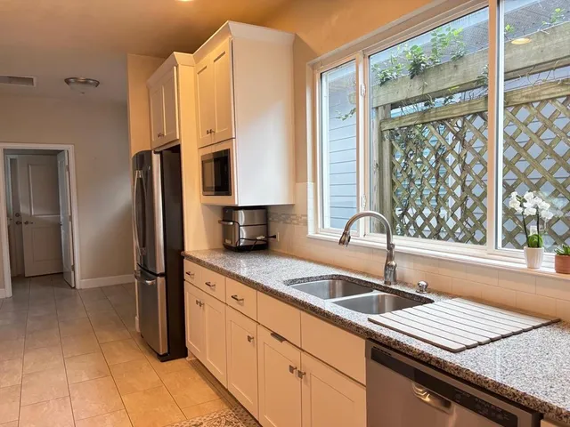 a kitchen with a sink a counter top space cabinets and stainless steel appliances