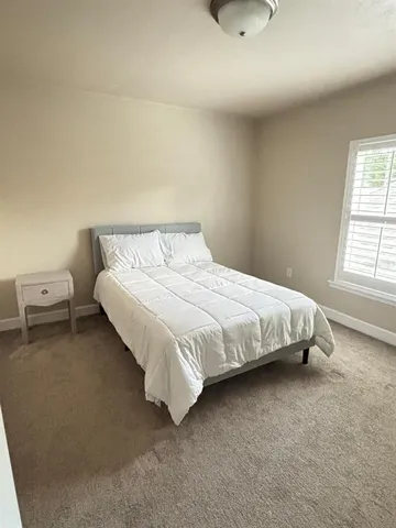 a bedroom with a bed and window