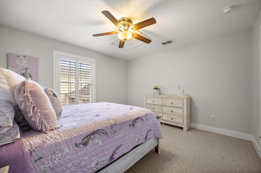 815 Spring Park Loop Celebration, FL 34747 - Photo 37 of 51 a bedroom with a bed and a ceiling fan