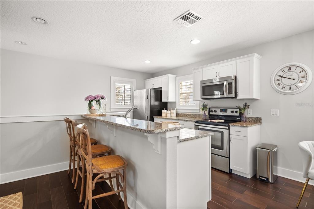 815 Spring Park Loop Celebration, FL 34747 - Photo 41 of 51 a kitchen with stainless steel appliances a stove a sink cabinets and a dining table