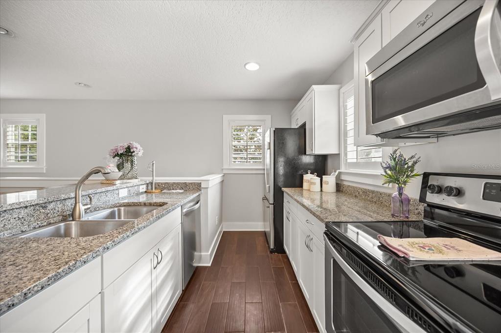 815 Spring Park Loop Celebration, FL 34747 - Photo 42 of 51 a kitchen with stainless steel appliances granite countertop a sink stove and refrigerator