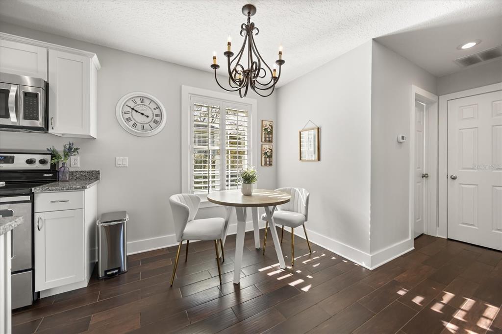 815 Spring Park Loop Celebration, FL 34747 - Photo 44 of 51 a dining room with wooden floor a chandelier a wooden table and chairs