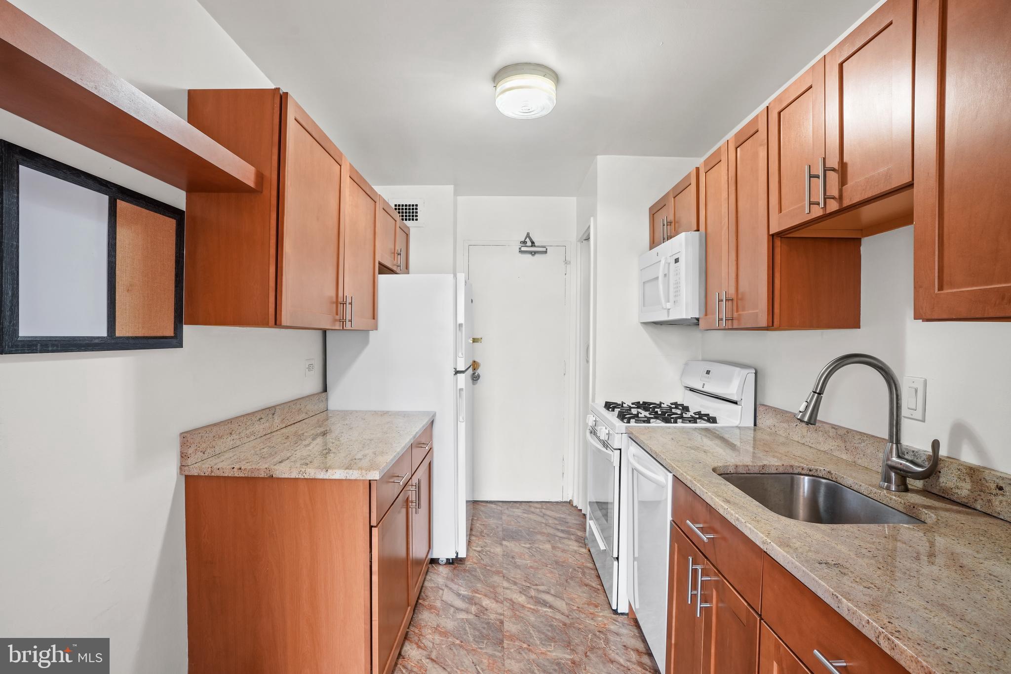 1900 Lyttonsville Road, Unit 612 Silver Spring, MD 20910 - Photo 3 of 23 a kitchen with stainless steel appliances granite countertop a sink stove and refrigerator