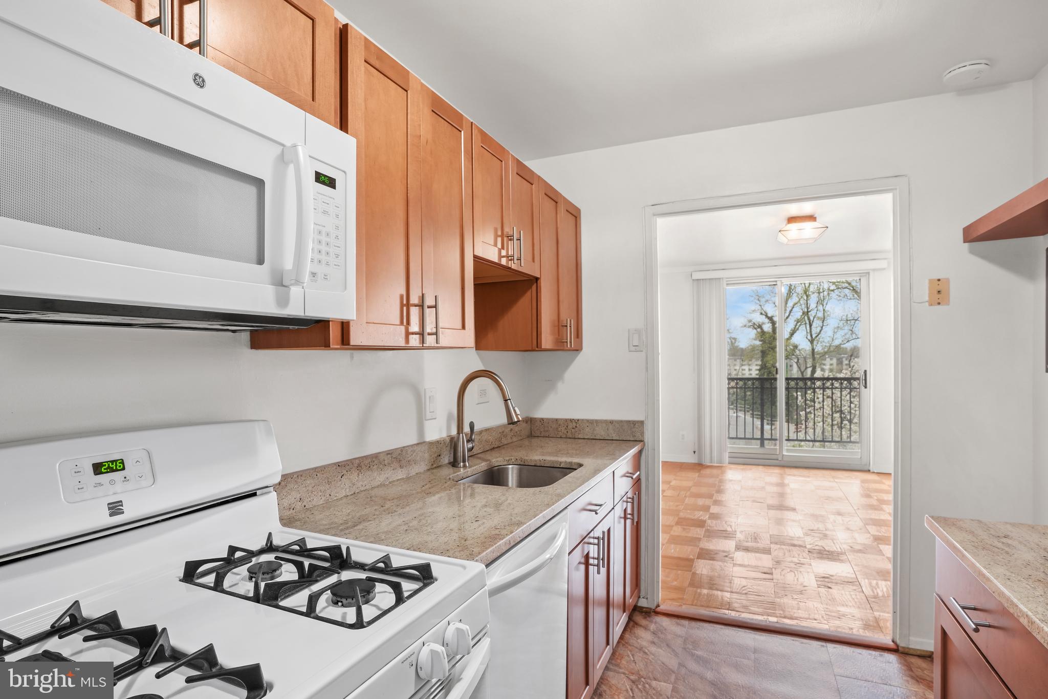 1900 Lyttonsville Road, Unit 612 Silver Spring, MD 20910 - Photo 4 of 23 a kitchen with a stove a sink and a microwave