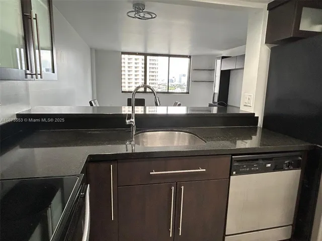 a kitchen with granite countertop a sink and a stove