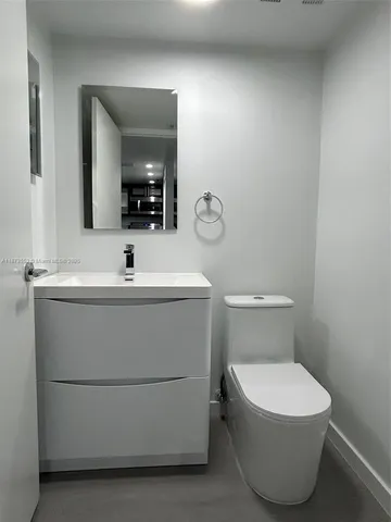 a bathroom with a sink a toilet and mirror