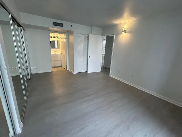 an empty room with wooden floor and a window