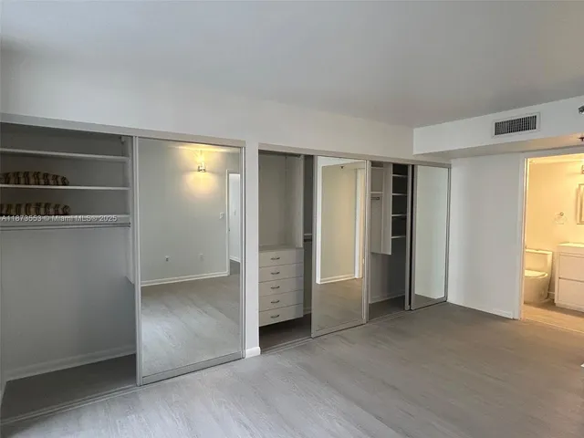 an empty room with closet and wooden floor