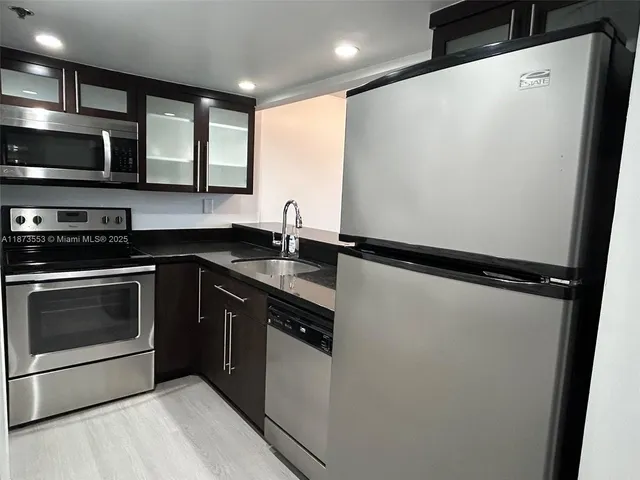 a kitchen with stainless steel appliances a refrigerator sink and microwave