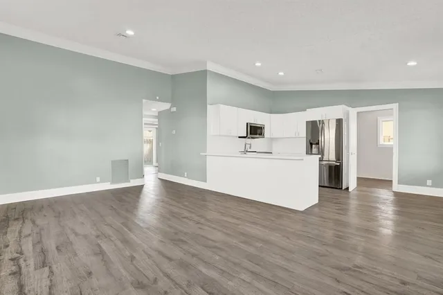 a view of a kitchen with wooden floor and a sink