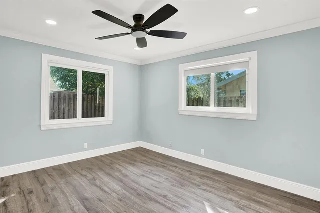 a view of a big room with wooden floor and windows