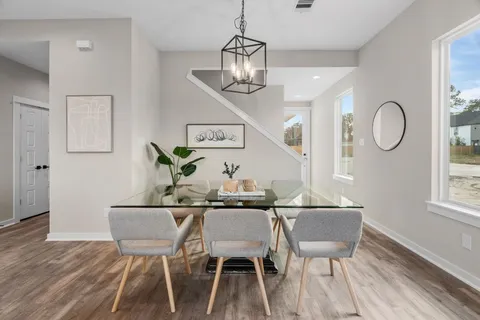 a living room with furniture a chandelier and a dining table