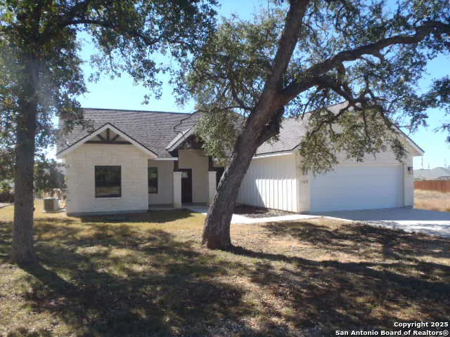 a view of a house with a tree in front of it