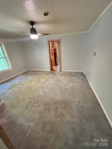 en empty room with windows and ceiling fan