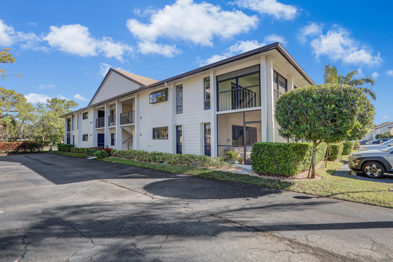 a view of a white house with a yard and plants