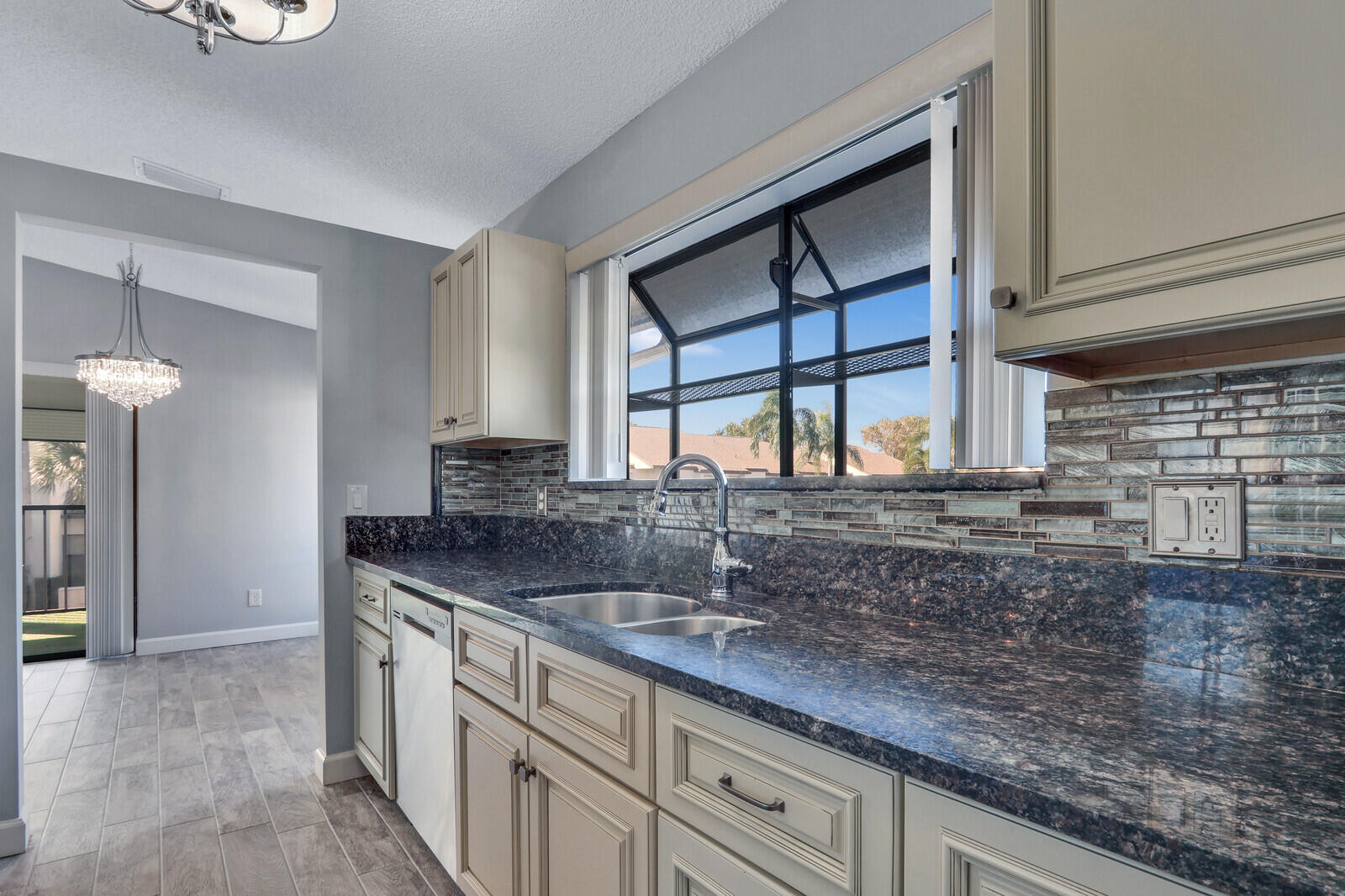 1102 Wingfoot Drive, Unit D Jupiter, FL 33458 - Photo 15 of 30 a kitchen with stainless steel appliances granite countertop a sink and a white cabinets