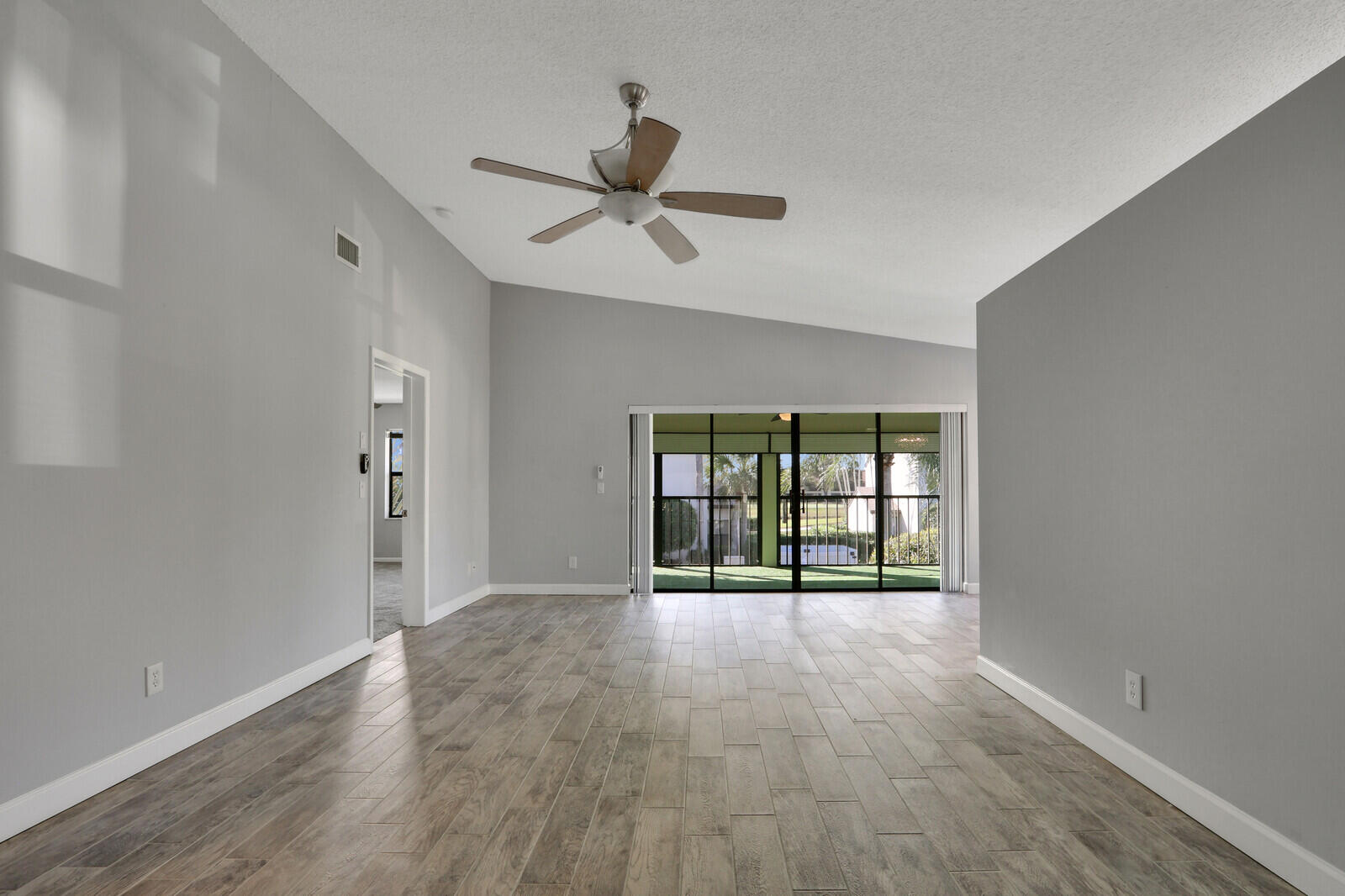 1102 Wingfoot Drive, Unit D Jupiter, FL 33458 - Photo 5 of 30 wooden floor in an empty room with a window