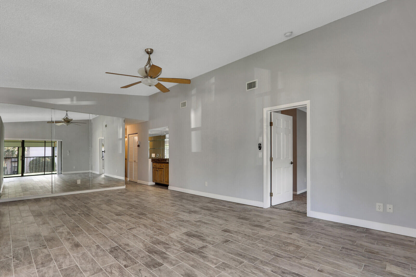 1102 Wingfoot Drive, Unit D Jupiter, FL 33458 - Photo 8 of 30 wooden floor in an empty room with a window