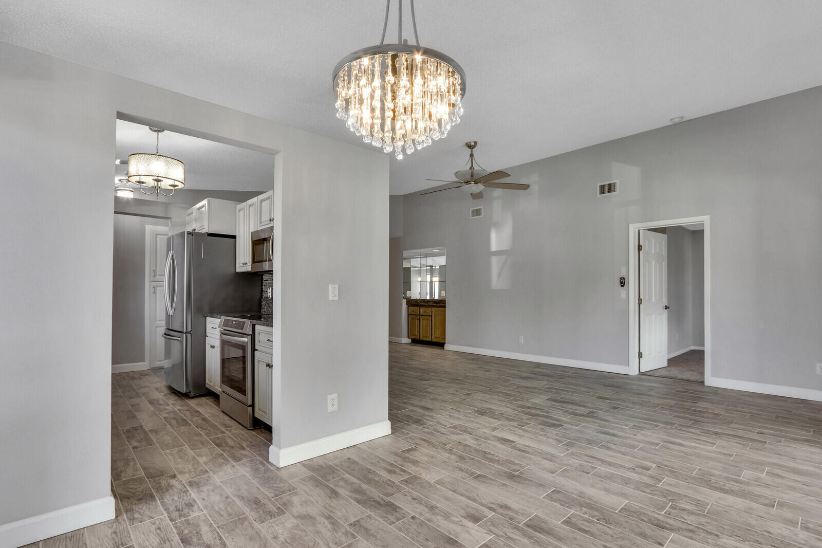 1102 Wingfoot Drive, Unit D Jupiter, FL 33458 - Photo 10 of 30 a view of a hallway with wooden floor and a chandelier