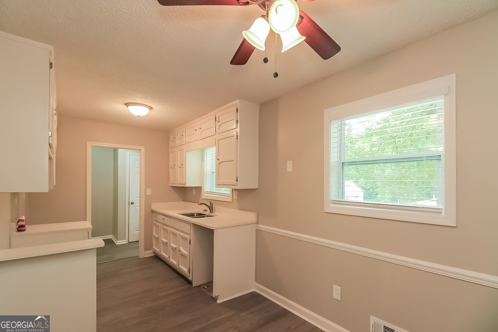 6862 Red Maple Drive Rex, GA 30273 - Photo 6 of 18 a kitchen that has a lot of cabinets and wooden floor