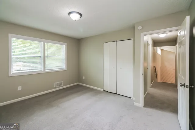an empty room with windows and closet