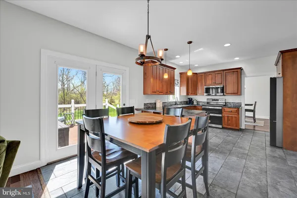 a dining room with furniture a chandelier and wooden floor
