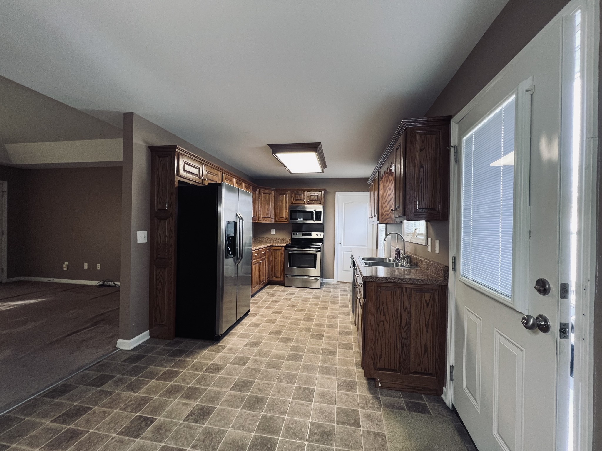 8659 Dog Branch Road Mount Pleasant, TN 38474 - Photo 17 of 36 a kitchen with stainless steel appliances kitchen island granite countertop a refrigerator and a sink