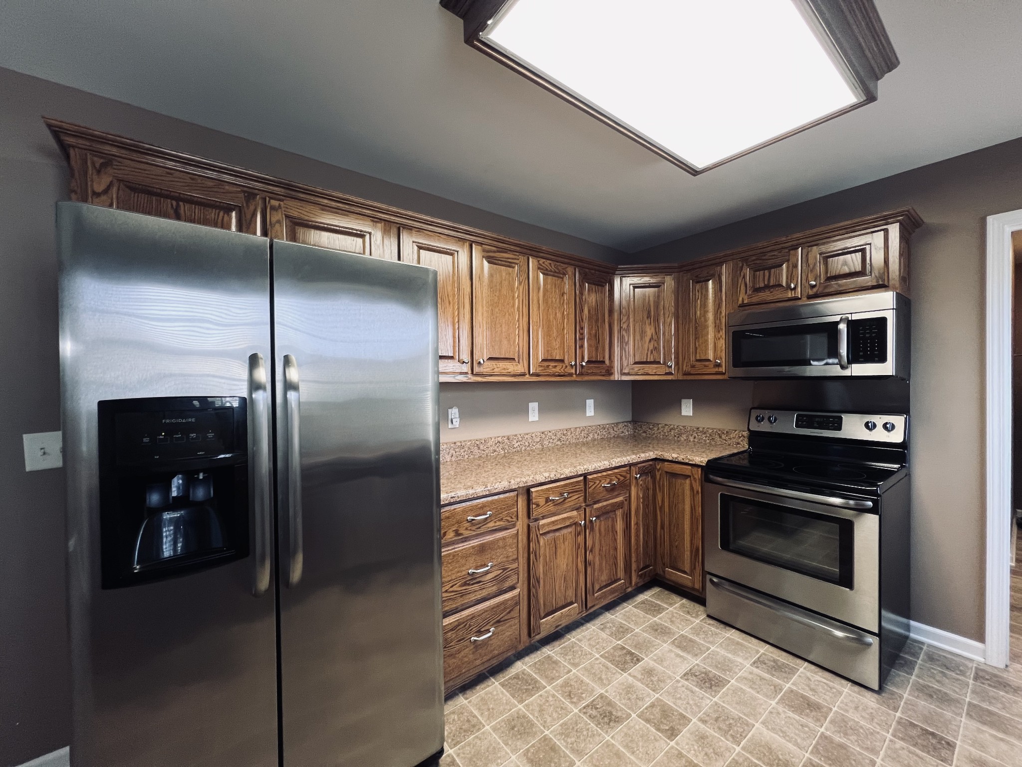 8659 Dog Branch Road Mount Pleasant, TN 38474 - Photo 20 of 36 a kitchen with stainless steel appliances granite countertop a refrigerator a sink a stove and cabinets