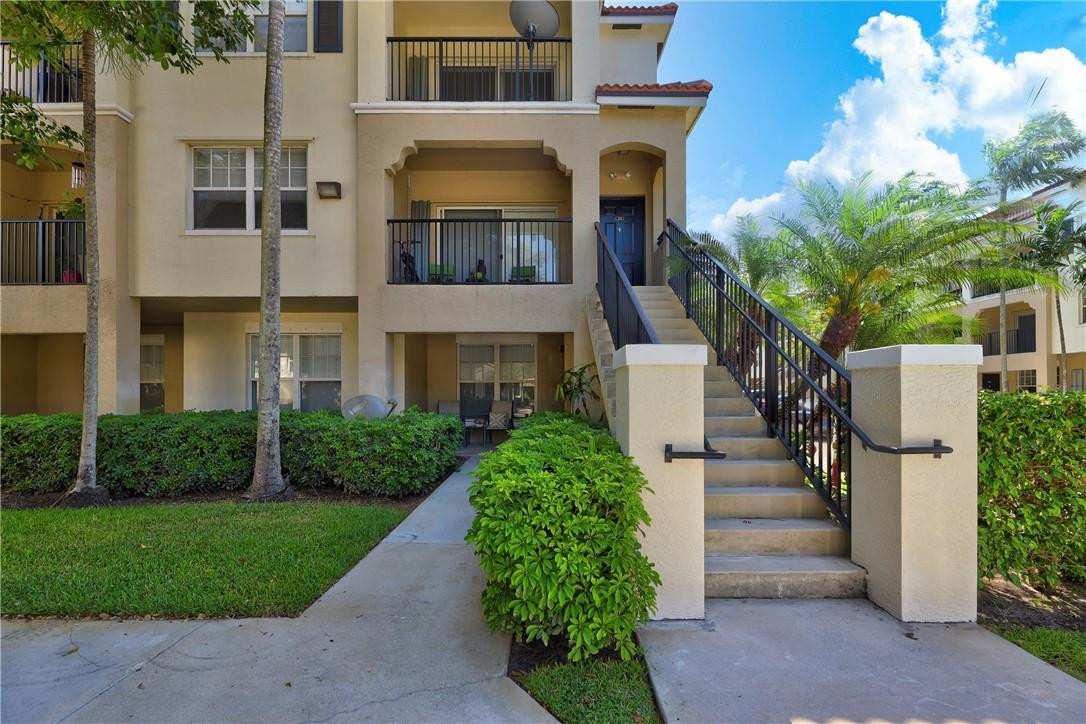 5840 West Sample Road, Unit 308 Coral Springs, FL 33067 - Photo 1 of 54 a front view of a house with a garden