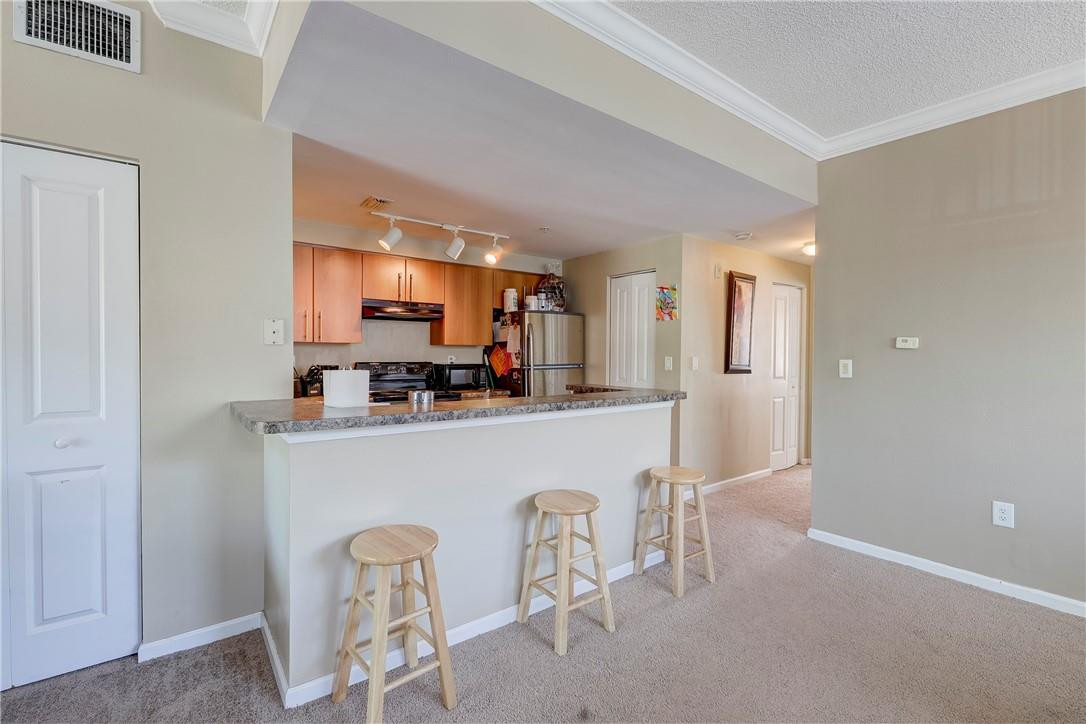 5840 West Sample Road, Unit 308 Coral Springs, FL 33067 - Photo 12 of 54 a kitchen with stainless steel appliances a refrigerator and a wooden cabinets