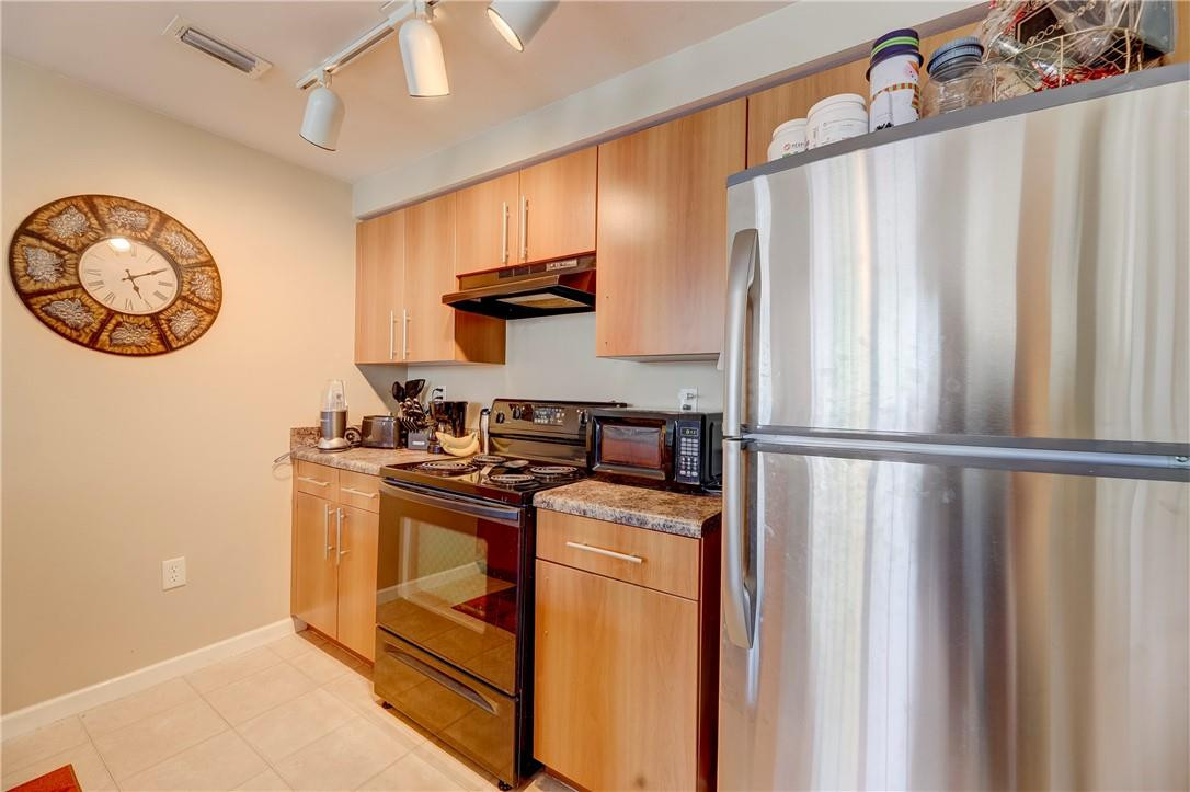 5840 West Sample Road, Unit 308 Coral Springs, FL 33067 - Photo 15 of 54 a kitchen with a refrigerator and a stove